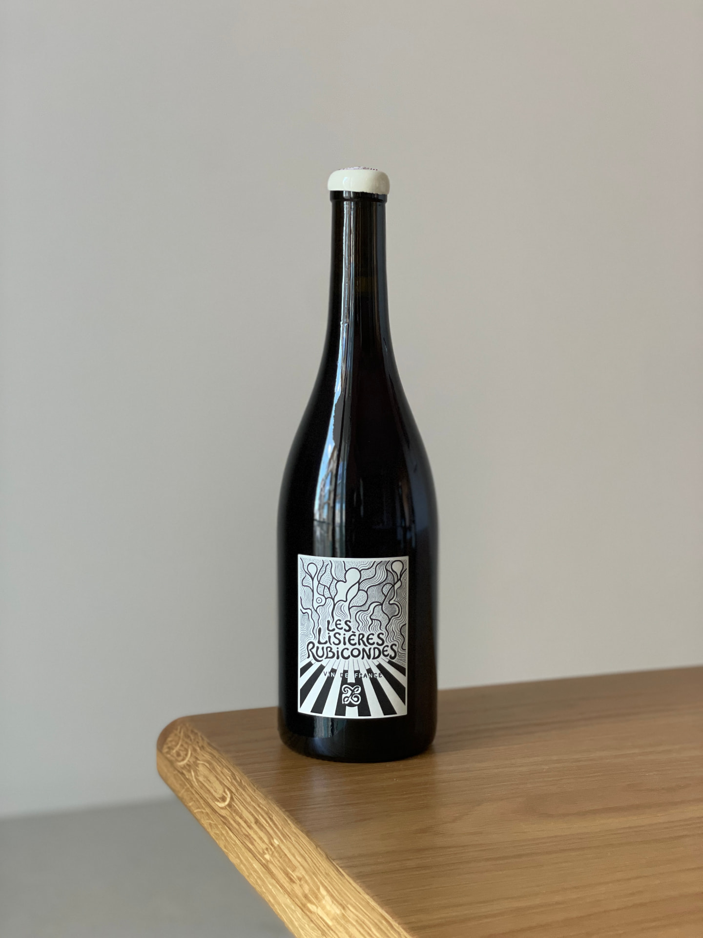 Bouteille « Les Lisières Rubicondes », Vin de France, étiquette dessinée en noir et blanc, posée sur une table en bois