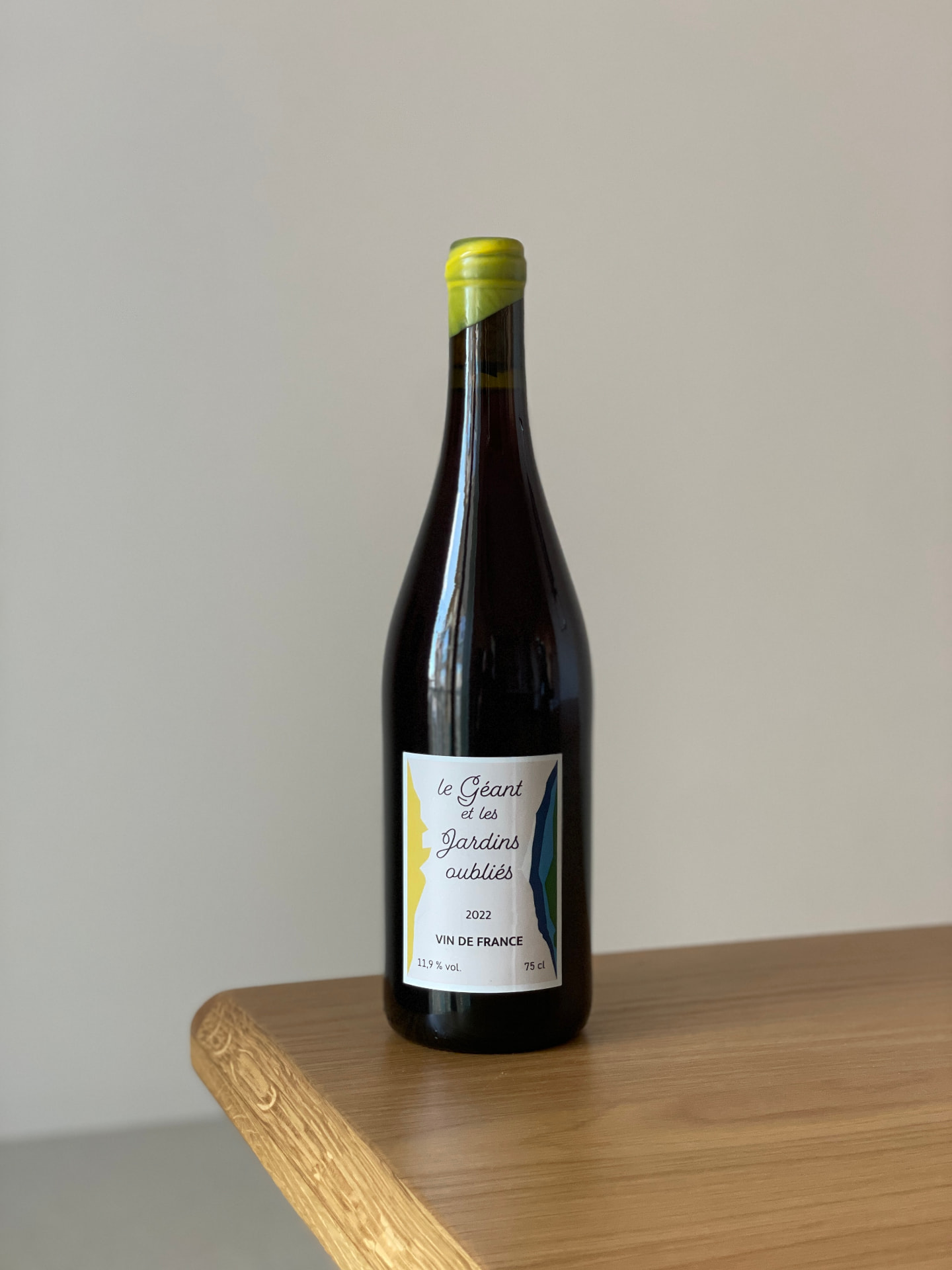 Bouteille « Le Géant et les Jardins Oubliés », millésime 2022, Vin de France, bouchon jaune, posée sur une table en bois