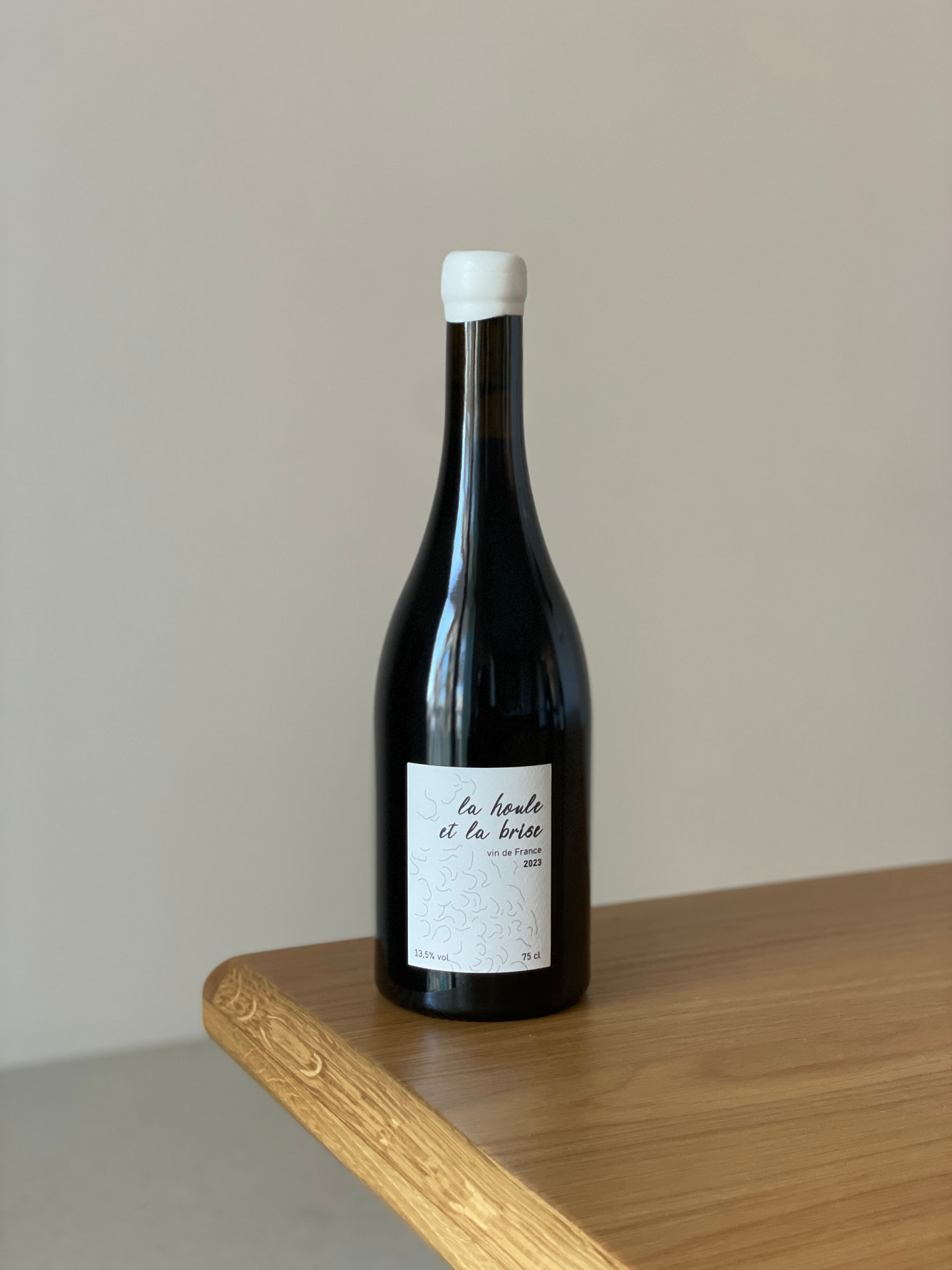 Bouteille « La Houle et la Brise », vin de France 2023, bouchon blanc, posée sur une table en bois