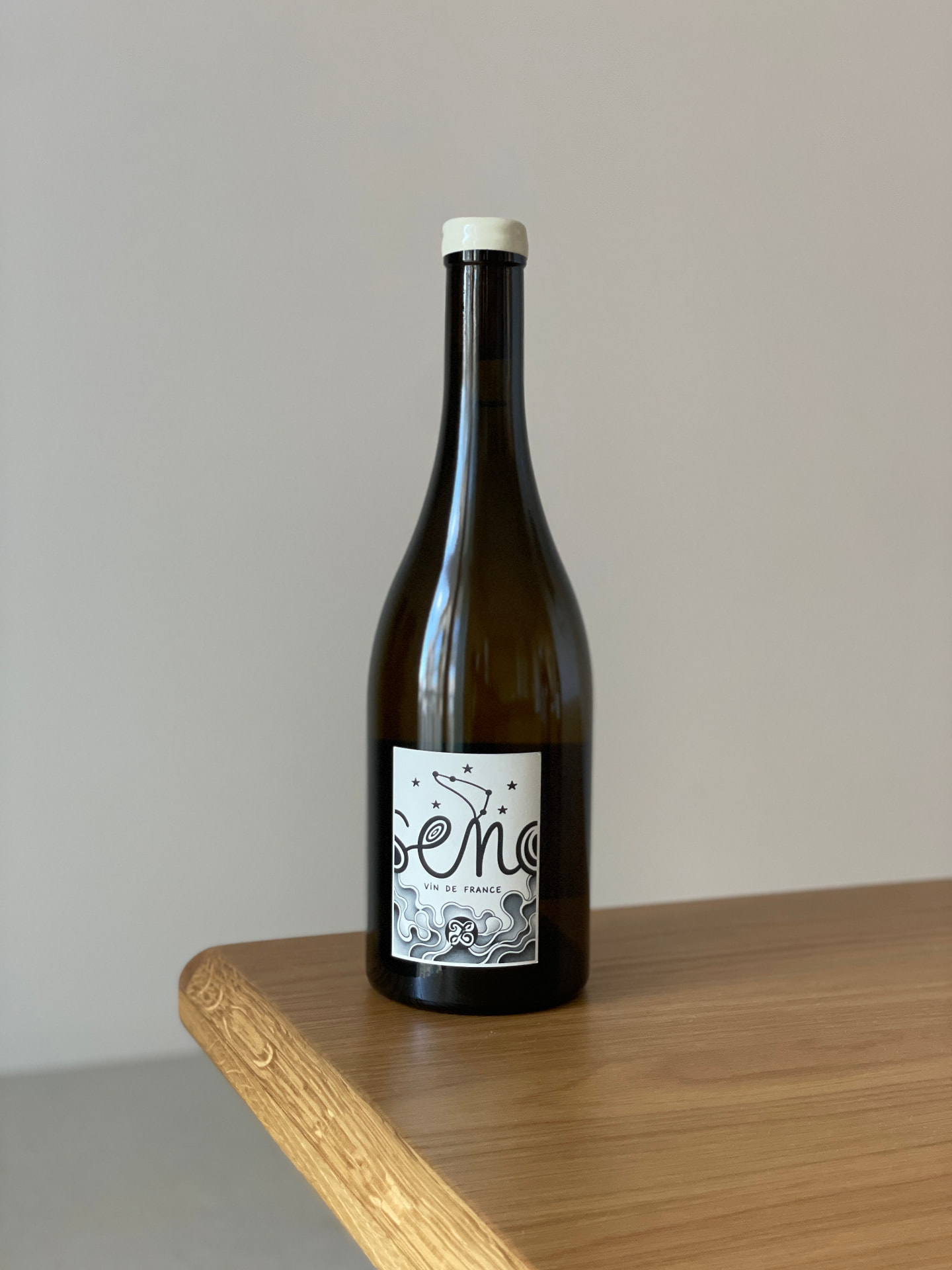 Bouteille « Seno », Vin de France, étiquette dessinée avec constellations, posée sur une table en bois